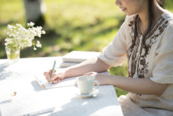 自然の中で手紙を書く女性